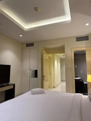 a bedroom with a white bed and a television at Spacious 2BR in DAMAC - Burj View in Dubai