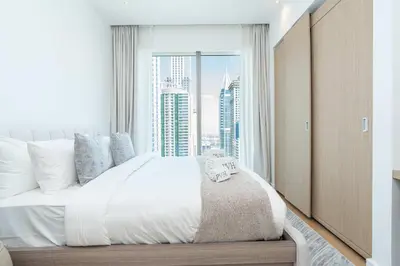 a bedroom with a large bed with a large window at PVH - Marina Gate 2 - Harmonious 2BR with Sea View in Dubai