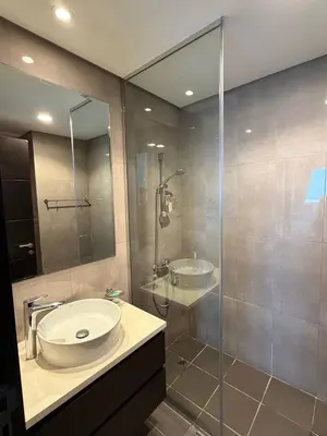 a bathroom with a sink and a glass shower at 1BR Canal Views Large Balcony Spacious BusinessBay in Dubai