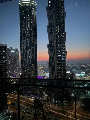 two tall skyscrapers in a city at night at 1BR Canal Views Large Balcony Spacious BusinessBay in Dubai