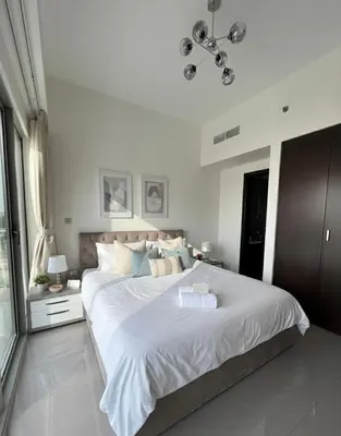 a white bedroom with a large bed with white sheets at 1BR Canal Views Large Balcony Spacious BusinessBay in Dubai