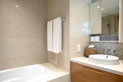 a bathroom with a sink and a tub and a mirror at New 1BR Burj View Infinity Pool 5min Dubai mall in Dubai