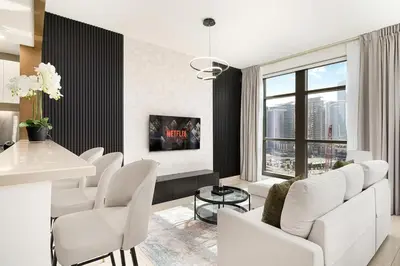 a living room with white chairs and a large window at New 1BR Burj View Infinity Pool 5min Dubai mall in Dubai