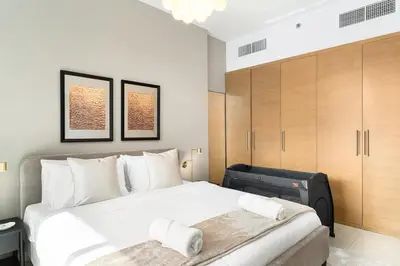 a bedroom with a large white bed with a suitcase at New 1BR Burj View Infinity Pool 5min Dubai mall in Dubai