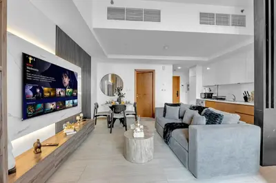 a living room with a couch and a table at The Fitness Suite JVC - Pool View - Zaya Hameni in Dubai