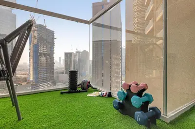 a room with a view of a city from a window at The Fitness Suite JVC - Pool View - Zaya Hameni in Dubai