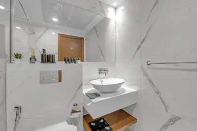 a white bathroom with a sink and a mirror at The Fitness Suite JVC - Pool View - Zaya Hameni in Dubai