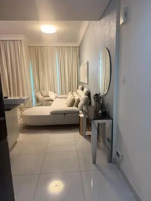 a living room with a couch and a mirror at Damac Maison mall street in Dubai