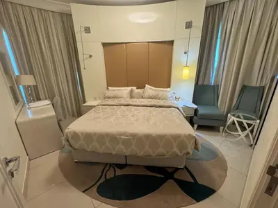 a hotel room with a bed and a chair at Damac Maison mall street in Dubai