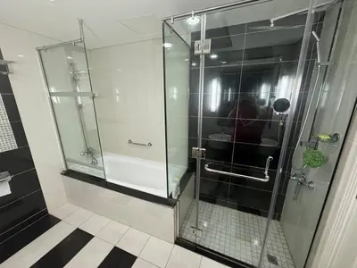 a shower with a glass door in a bathroom at Damac Maison mall street in Dubai