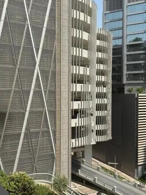 two tall buildings in a city with a train at Damac Maison mall street in Dubai