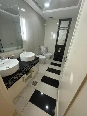 a bathroom with two sinks and two toilets at Damac Maison mall street in Dubai