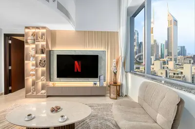 a living room with a television with a large window at Sky Gardens By Luxe Living Collection - Duplex 2BR - DIFC in Dubai