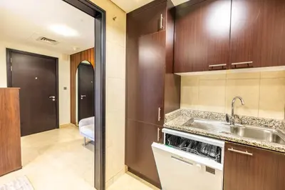 a kitchen with wooden cabinets and a sink in a room at Sky Gardens By Luxe Living Collection - Duplex 2BR - DIFC in Dubai