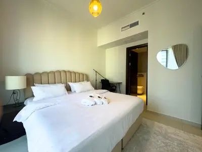 two dogs sitting on top of a white bed at Werova- Waterfront 1-Bedroom Apartment Furnished in Dubai