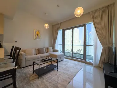 a living room with a couch and a table at Werova- Waterfront 1-Bedroom Apartment Furnished in Dubai