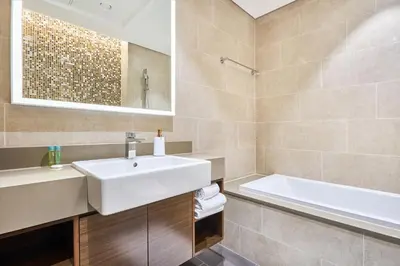 a bathroom with a white sink and a bath tub at STAY BY LATINEM Luxury 2BR Holiday Home G5- 5812 near Burj Khalifa in Dubai