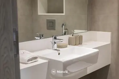 a bathroom with a white sink and a mirror at 1BR Urban Living near Downtown in District One in Dubai