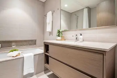 a bathroom with a sink and a tub and a mirror at Frank Porter - Grande Signature in Dubai