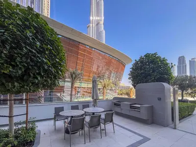 a patio with a table and chairs in front of a building at Frank Porter - Grande Signature in Dubai