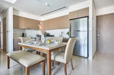 a kitchen with a table and chairs and a refrigerator at Frank Porter - Grande Signature in Dubai