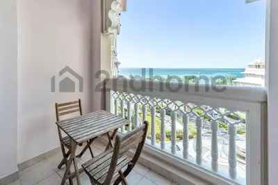 a table and chairs on a balcony with a view of the ocean at Beachfront Escape Sea-View Balcony Palm Jumeirah in Dubai