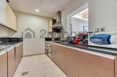 a kitchen with wooden cabinets and a counter top at Beachfront Escape Sea-View Balcony Palm Jumeirah in Dubai