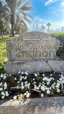 a sign in a park with white flowers at Beachfront Escape Sea-View Balcony Palm Jumeirah in Dubai