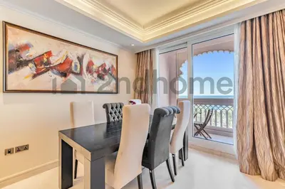 a dining room with a black table and chairs at Beachfront Escape Sea-View Balcony Palm Jumeirah in Dubai