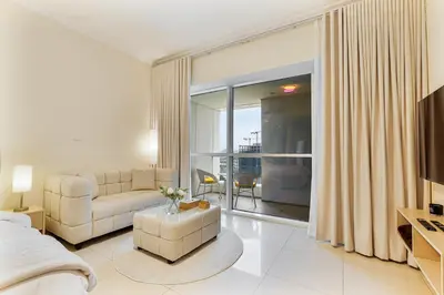a living room with a bed and a large window at Stylish JLT Studio in Dubai