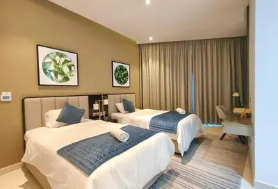a hotel room with two beds and a desk at Amazing Canal View 2 BR sweet retreat in Dubai
