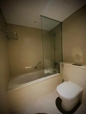 a bathroom with a toilet and a tub with a mirror at Amazing Canal View 2 BR sweet retreat in Dubai