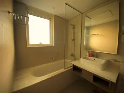 a bathroom with a sink and a tub and a mirror at Amazing Canal View 2 BR sweet retreat in Dubai