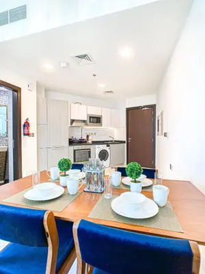 a kitchen and dining room with a table and chairs at Chic Urban Escape 1BR Sleeps- 4 In Bayz-18 in Dubai
