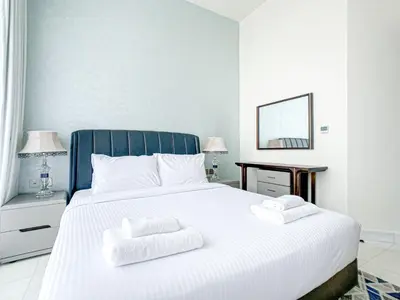 a bedroom with a white bed with two towels on it at Chic Urban Escape 1BR Sleeps- 4 In Bayz-18 in Dubai
