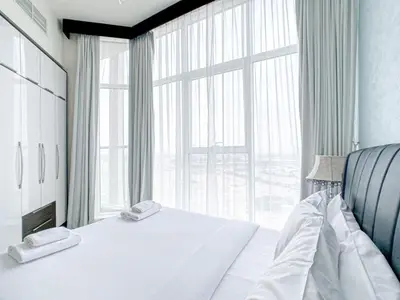 a bedroom with a bed and a large window at Chic Urban Escape 1BR Sleeps- 4 In Bayz-18 in Dubai