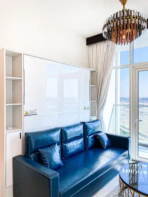 a blue couch in a living room with a window at Chic Urban Escape 1BR Sleeps- 4 In Bayz-18 in Dubai