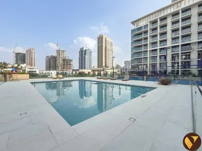 a large swimming pool in front of a tall building at Vogue JVC Binghatti Phoenix near Circle Mall, One Bedroom Apartment with Balcony and Access to all Amenities in Dubai
