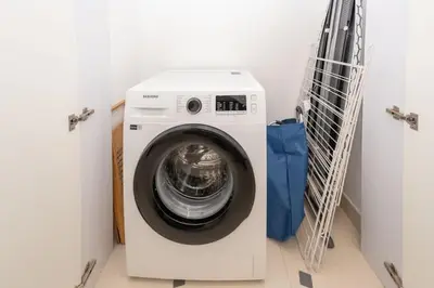 a washing machine sitting in a laundry room with doors at Stylish 1BR Stay in City Walk Building 10 in Dubai