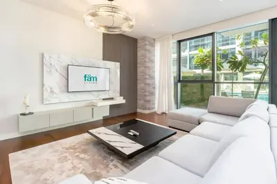 a living room with a white couch and a tv at Elegant 2BR with Maids Room City Walk in Dubai