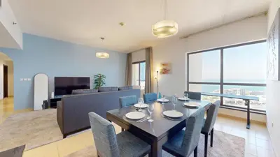 a dining room and living room with a table and chairs at Vacationer l Cozy 2 Bed l Breathtaking Sea and Ain Dubai Views in Dubai