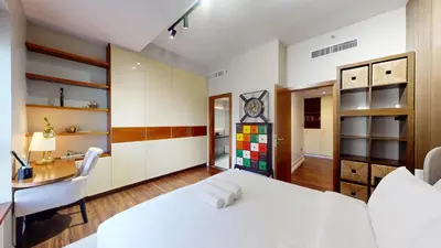 a bedroom with a white bed and a desk at Vacationer l Mesmerizing 2 Bed l Sea and Ain Dubai View l JBR in Dubai