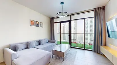 a living room with a couch and a large window at Vacationer l 1 Bedroom in Creek Harbour l Skyline Views in Dubai