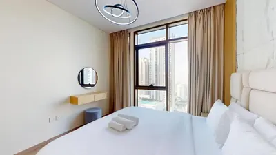 a bedroom with a white bed and a large window at Vacationer l 1 Bedroom in Creek Harbour l Skyline Views in Dubai