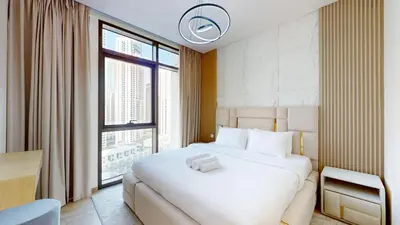 a bedroom with a white bed and a large window at Vacationer l 1 Bedroom in Creek Harbour l Skyline Views in Dubai