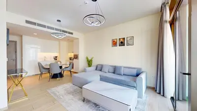 a living room with a blue couch and a table at Vacationer l 1 Bedroom in Creek Harbour l Skyline Views in Dubai