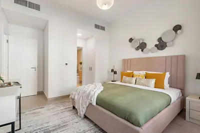 a bedroom with a large bed with orange and green pillows at The Smart Concierge - Andalus Jumeirah Golf Estates in Dubai