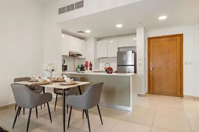 a kitchen and dining room with a table and chairs at The Smart Concierge - Andalus Jumeirah Golf Estates in Dubai