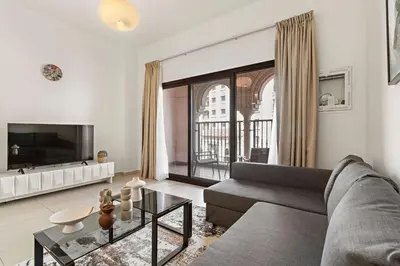 a living room with a couch and a large window at The Smart Concierge - Andalus Jumeirah Golf Estates in Dubai