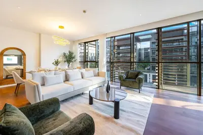 a living room with a white couch and chairs at Elegant 3BR with Maids Room City Walk Dubai in Dubai
